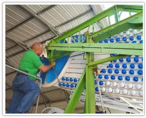 Worker installing blue AT&T-branded light covers on a Ferris wheel