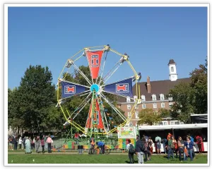 University of Illinois Ferris wheel with orange and blue sponsor panels at a campus event