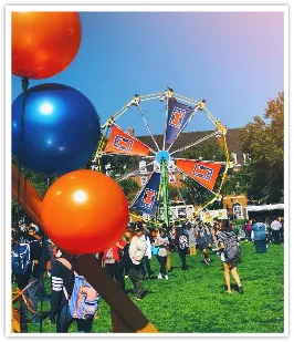 University of Illinois Ferris wheel behind orange and blue balloons at a crowded campus event